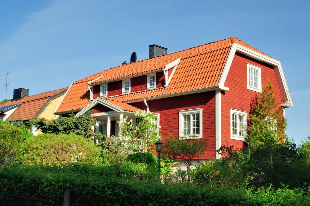 En stor röd trävilla i ett bostadsområde.